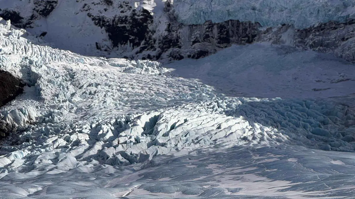 A guide leading hikers past a moulin on the Beyond the Limit six-hour Skaftafell glacier hike on Falljökull, Iceland